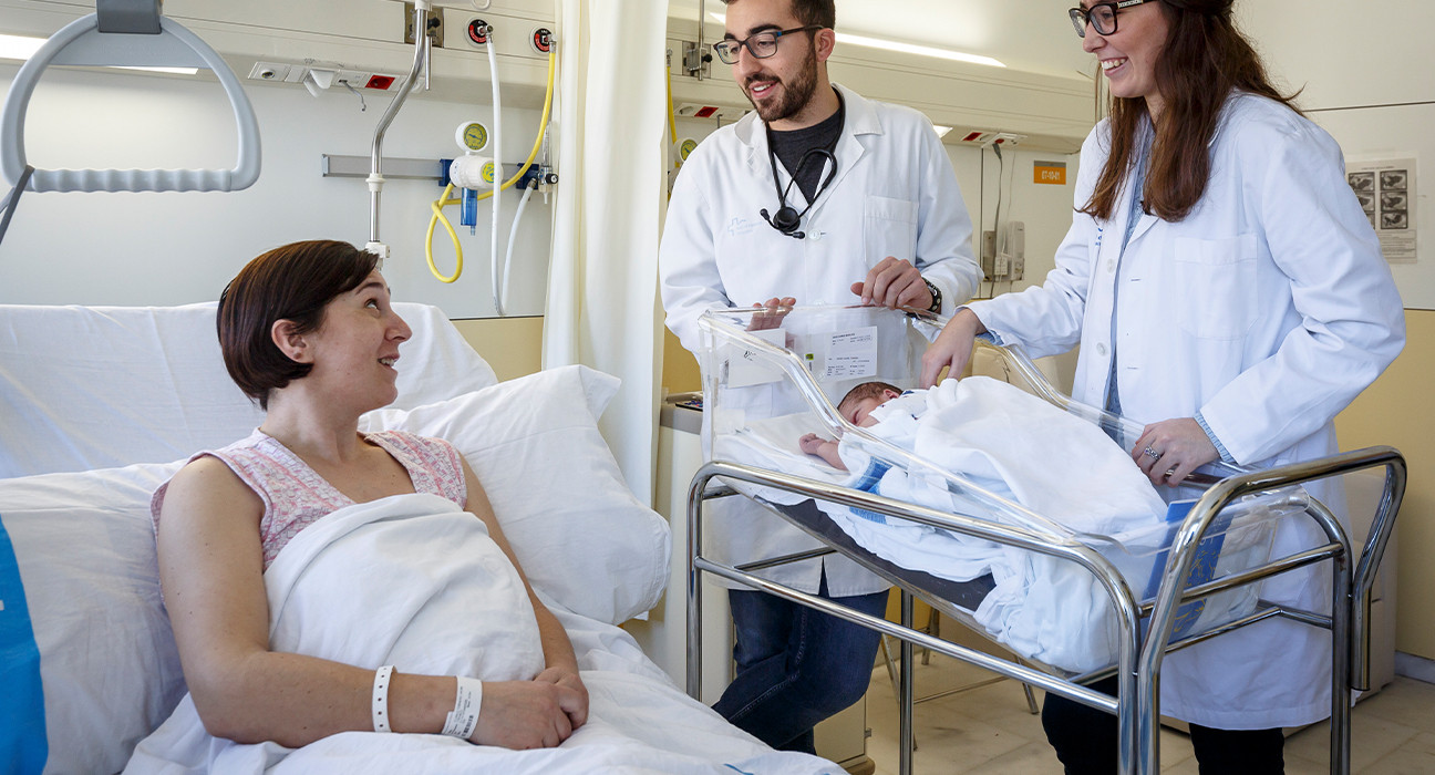 Mare amb el seu fill parlant amb professionals de Vall d'Hebron a l'habitació